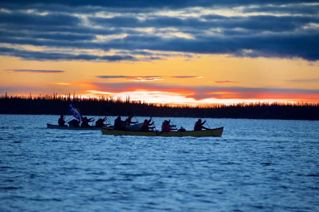 traditional canoe on the water, under a sunset in Gameti